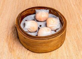 Steamed Shrimp Dumpling King served in bamboo steamer isolated on wooden table side view of hong kong food photo