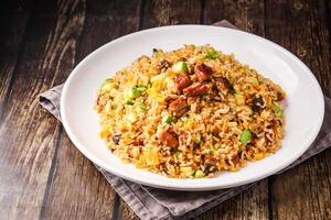 Japanese style eel fried rice including cucumber and egg served on plate isolated on napkin side view of hong kong food on wooden background photo