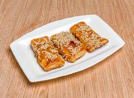 Fragrant BBQ Pork Cake topped with sesame seeds served in tray dish isolated on wooden table side view of hong kong food photo