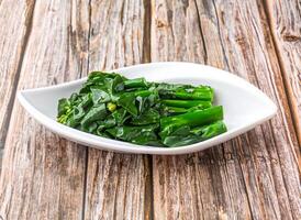 Sauteed Choy Sum or Chinese Broccoli with a touch of garlic and oyster sauce served in dish isolated on wooden table side view of hong kong food photo
