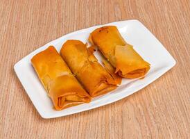 Fried Garlic Shrimp Spring Rolls served in tray dish isolated on wooden table side view of hong kong food photo