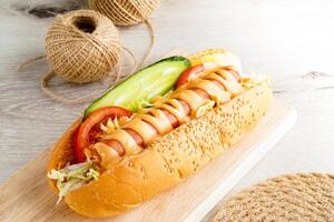 Classic Hot Dog with Mustard and Topping with ketchup, lettuce, tomato, and cucumber served on a wooden board side view of USA fast food photo