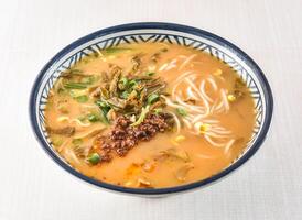 Hot and sour rice noodles soup with minced pork and green onion served in bowl isolated on white background side view of hong kong food photo