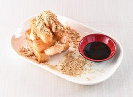 Brown sugar glutinous rice cake with soy sauce served in tray dish isolated on white background side view of hong kong food photo