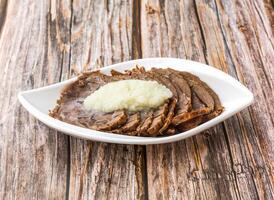 Garlic Beef Stew topped with garlic paste served in dish isolated on wooden table side view of hong kong food photo