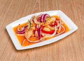 Thai style Sour and Spicy Chicken Feet with onion, tomato and sesame seeds served in tray dish isolated on wooden table side view of hong kong food photo