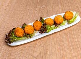 Crispy Golden Flower Balls with lettuce leave served in tray dish isolated on wooden table side view of hong kong food photo
