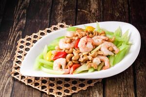 Shrimp with Celery and Cashew Nuts served in dish isolated on wooden background side view of hong kong food photo