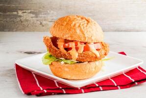 Gillette Pork Chop burger or buns including tomato, mayo, lettuce leave and cheese served on plate isolated on napkin side view of hing kong fast food on wooden background photo