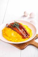 Grilled eel with fluffy egg omelette and rice served in plate isolated wooden board side view of hong kong food on wooden table photo
