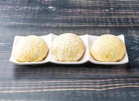 Chinese Barbecued Pork Buns served in tray dish isolated on wooden table side view of hong kong food photo