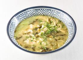 Pickled Fish Rice Noodles Soup topped with scallions served in bowl isolated on white background side view of hong kong food photo