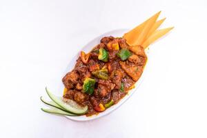Chicken Jhal Fry or jalfrezi topped with tomato, carrot and cucumber served on white plate isolated on white background top view of thai and bangladeshi food photo