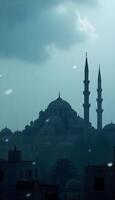 A silhouette of a Middle Eastern city skyline showcasing ornate domed buildings and towering minarets against a foggy, gray background during a rainstorm, with raindrops visible in the foreground photo