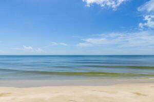 Motion of the wave on the beach with blue sky and clouds. photo