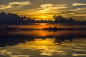 Sunset sky with cloud and silhouette mountain at the lake. photo