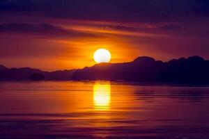 Sunset sky with cloud and silhouette mountain at the lake. photo