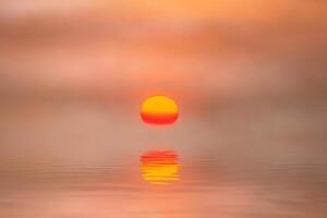 Sunset reflection at the lake with soft mist. photo