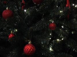 Christmas tree decorated with red ornaments and glowing lights in prague New Year preparation decor photo
