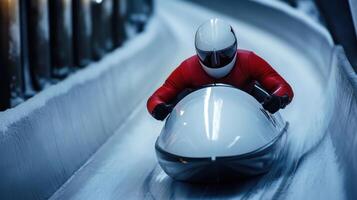 Professional athlete is sliding down the ice track on a luge during a race photo