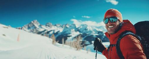 Smiling skier hiking up snowy mountain on sunny day photo