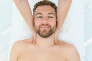 Handsome middle-aged man enjoying relaxing spa massage with oils photo