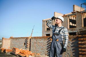 construction mason worker bricklayer installing red brick with trowel putty knife outdoors photo