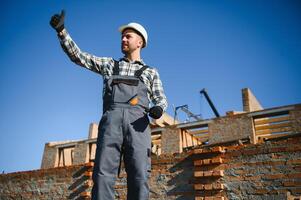 Installing brick wall. Construction worker in uniform and safety equipment have job on building photo