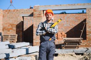 Installing brick wall. Construction worker in uniform and safety equipment have job on building photo