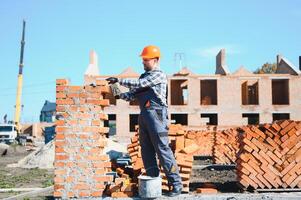 Construction worker in uniform and safety equipment have job on building photo