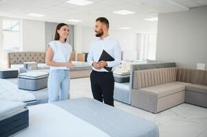 A professional sales consultant advises a client in a furniture store. photo