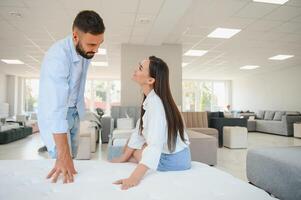 A young couple is choosing bedding at a bed, mattress and pillow store. Everything for a comfortable sleep photo