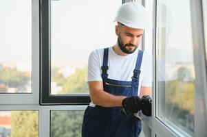 Worker installing plastic window indoors photo