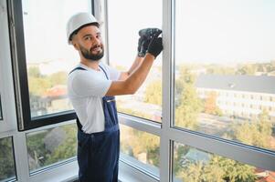 Worker installing plastic window indoors photo