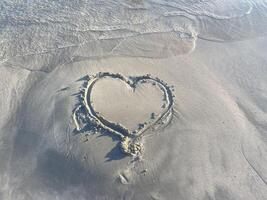 Drawing a heart in the sand. A heart is drawn on the beach photo