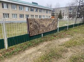 Carpet hanging on a fence photo