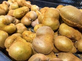 A stack of kiwis for sale at the market or grocery store photo