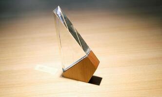 Business award made of glass and wood on a table with spotlights photo