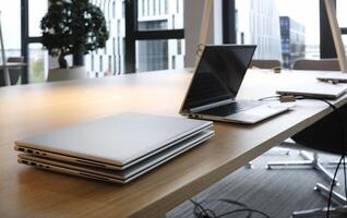 Row of laptops being prepared and set up for new employees in a company photo