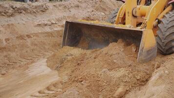 A construction vehicle digging and moving soil on a building site, showcasing heavy machinery in action. photo