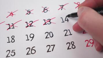 A hand marking important dates on a calendar, showing essential time management and organization skills for success photo