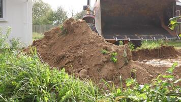 A busy construction site showcasing a massive dirt pile along with machinery meant for excavation and digging work photo