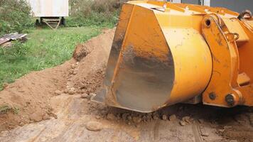 A heavy machinery excavator bucket is currently engaged in digging soil specifically for construction purposes photo