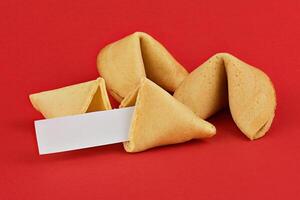 Fortune Cookies with Blank Fortune Slip on Vibrant Red Background with Copy Space photo
