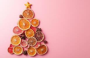 Christmas tree made of citrus slices on pink background photo