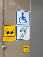 Information signs at entrance to building for people with disabilities with braille text photo