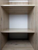 Empty shelf of wardrobe with place for clothes, shelf of wooden wardrobe without things, empty place for household items, vertical photo of shelves of spacious closet in interior of house