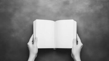 Hands Holding Open Book for Learning and Knowledge Concepts in Black and White Minimalist Design photo