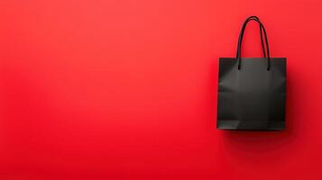 Black Shopping Bag on Vibrant Red Background Symbolizing Online Shopping and Retail Concepts photo