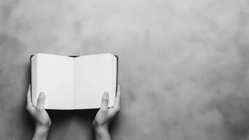 Hands Holding Open Blank Book Against Gray Background Symbolizing Knowledge and Learning with Space for Text or Design in Minimalist Style photo